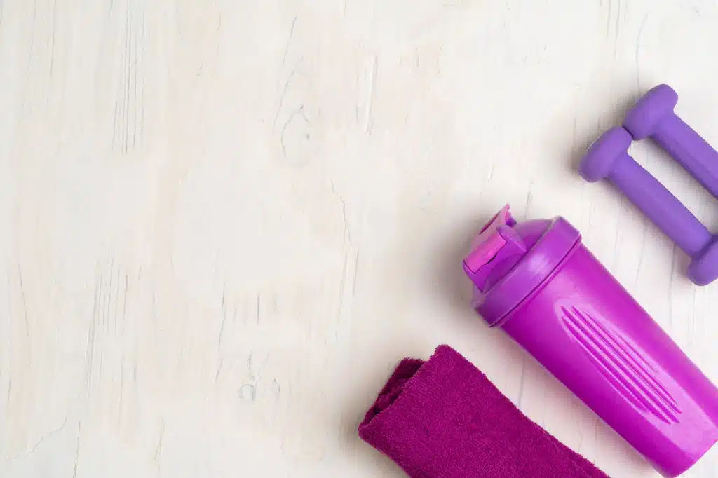 Small dumbbells, shaker and towel. Fitness concept, fitness supplements