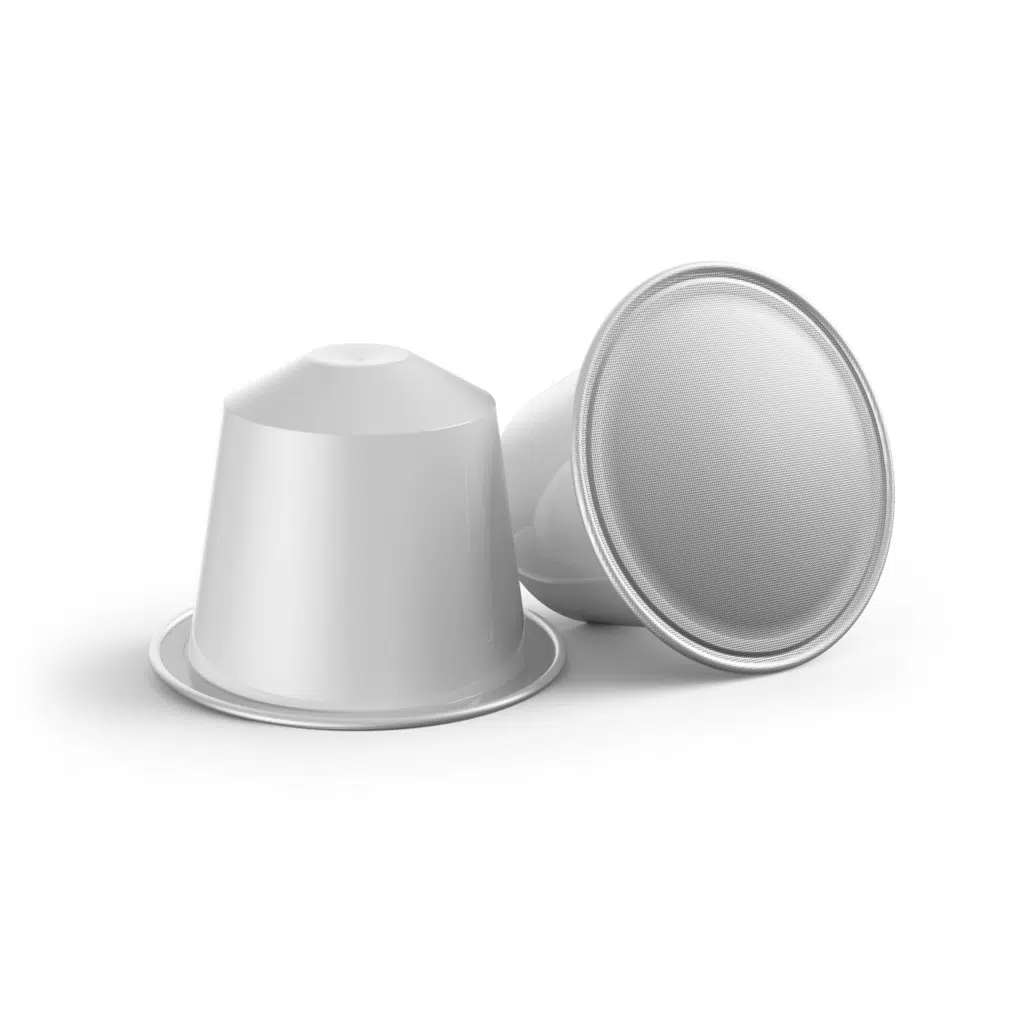 two coffee pods with white logo for private label laying on a table 