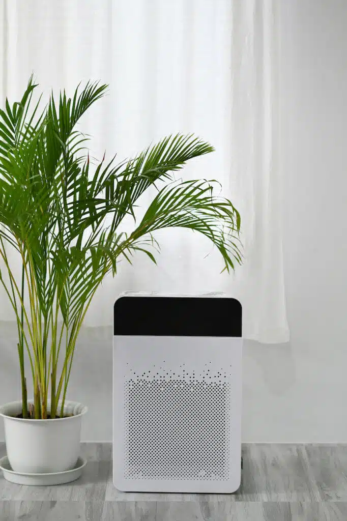 White modern air purifier on floor in bright living room for filter and cleaning removing dust PM2.5.
