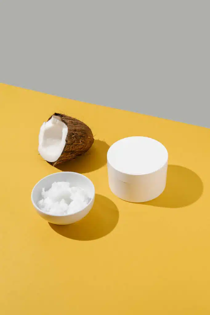 Half a coconut, coconut oil and a jar of coconut cream on a yellow background. A perfect demonstration of the composition of your product.