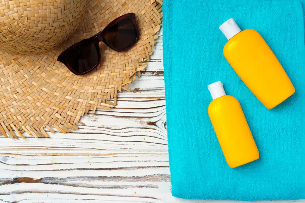 Beach hat and sunscreen bottle close up. Vacation concept