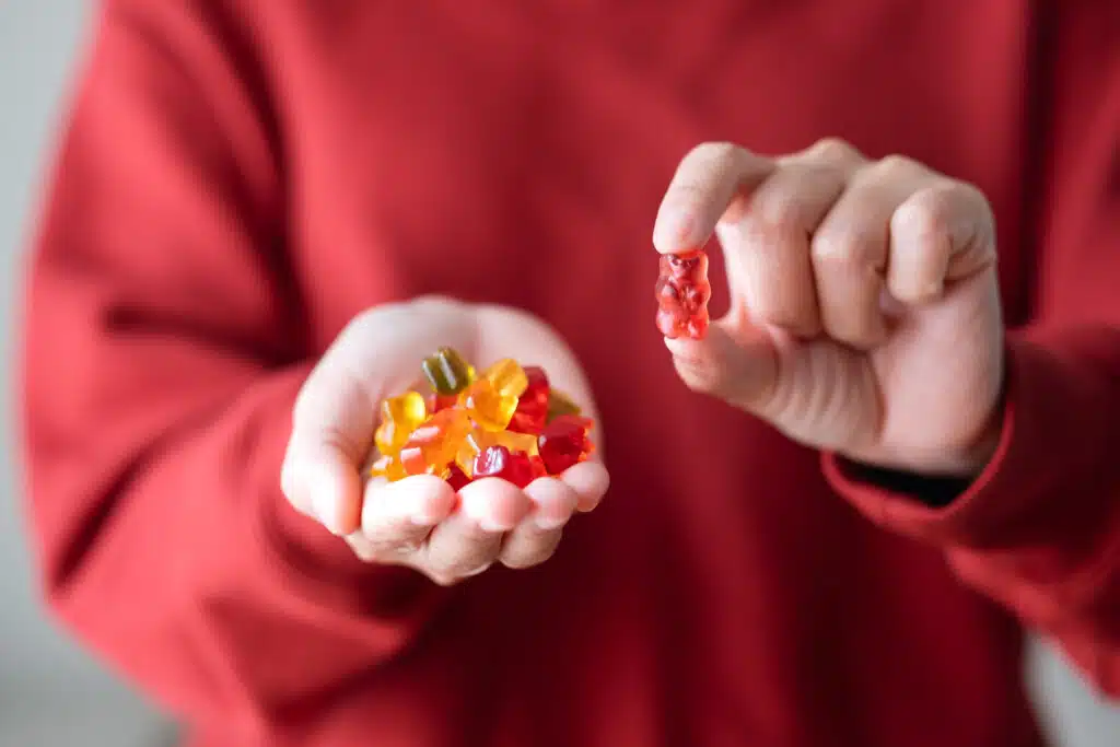 Closeup image of a woman holding and showing a jelly gummy bear