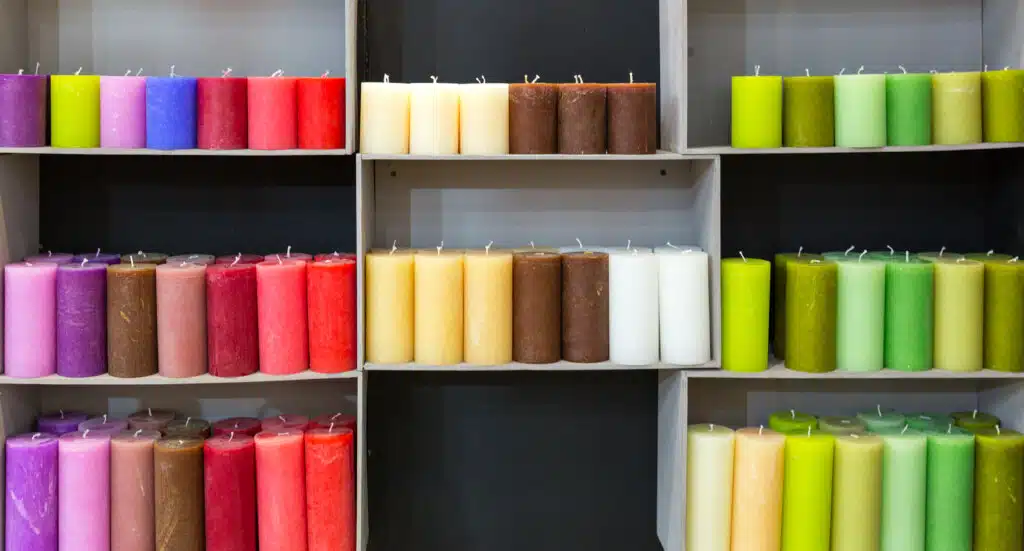 Colorful candles on shelf in decoration shop. Many candlelights for relax