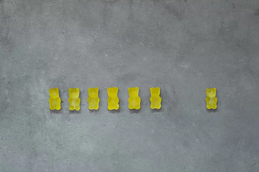 Yellow gummy bears on concrete background. Color of the year 2021 is ultimate gray and illuminating.