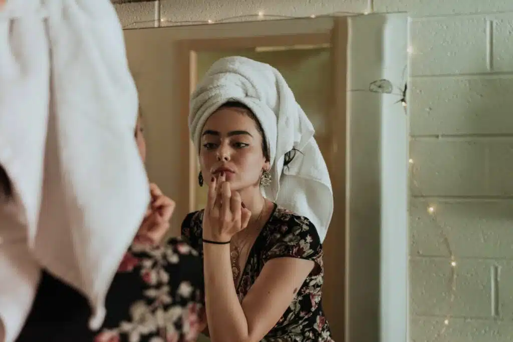 A woman delicately applying moisturizing lip cream, highlighting a step in her beauty routine.