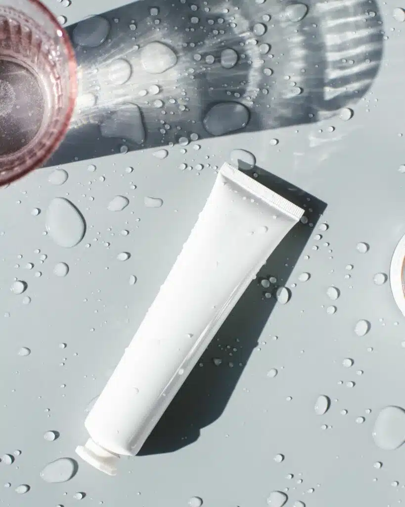 A squeeze tube of face cream, set on a neutral background.