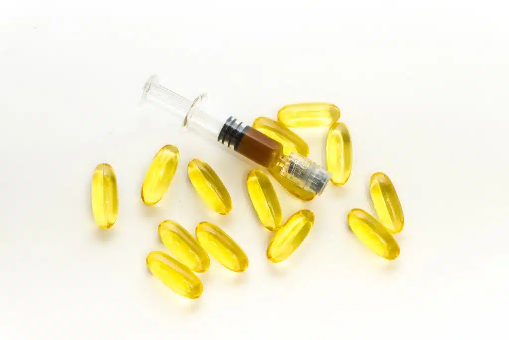 Cannabidiol CBD clear oil capsules and full spectrum Hemp paste on wooden table