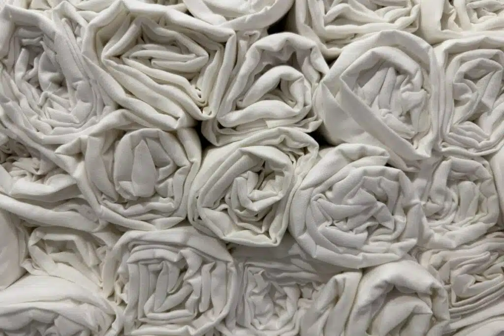 A stack of pristine white textiles, neatly folded and arranged, symbolizing purity, simplicity, and elegance.