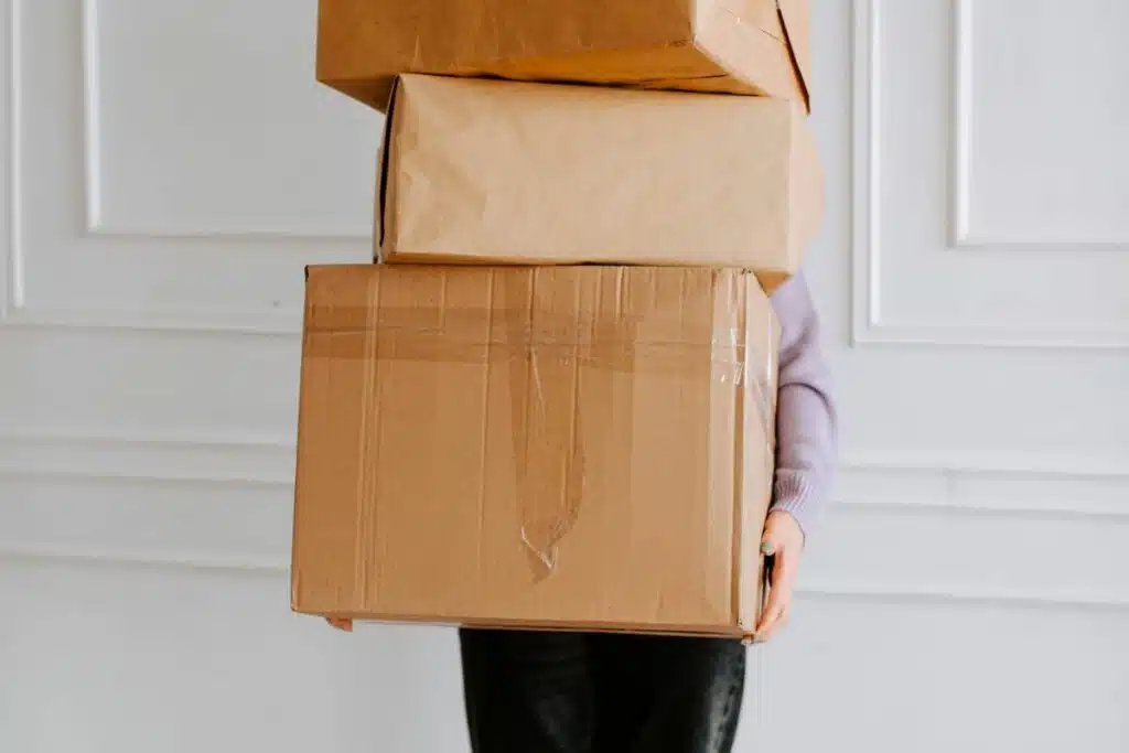 Woman holding multiple packages, ready for delivery.