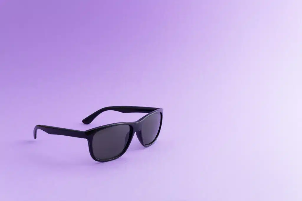 Black sunglasses over purple background