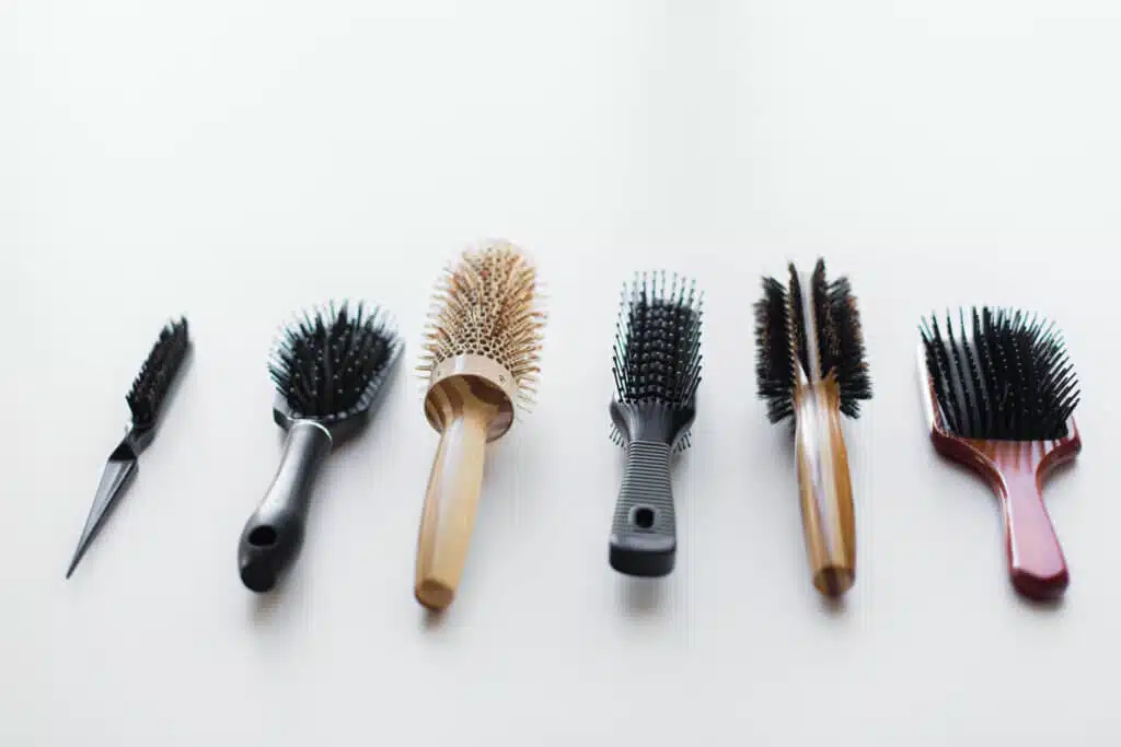 hair tools, beauty and hairdressing concept - different brushes or combs on white background