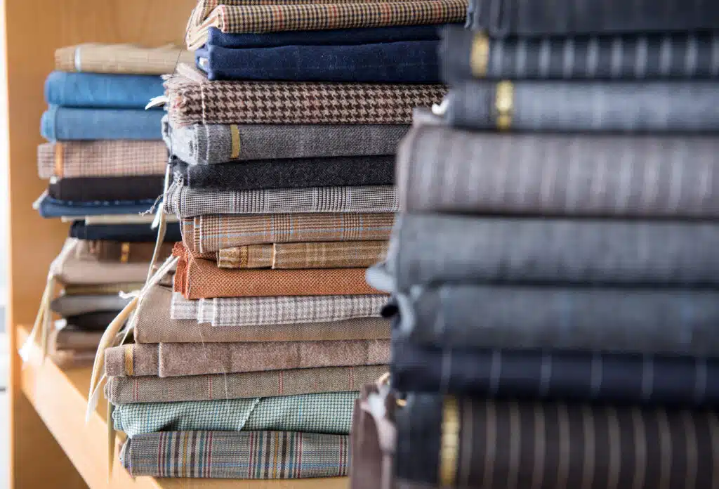 Close up view of fabrics stacks on shelf in tailor workshop