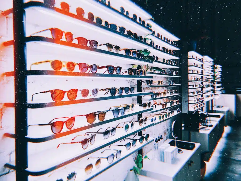 A captivating array of colorful sunglasses neatly arranged on shelves, exhibiting a wide variety of styles and hues.