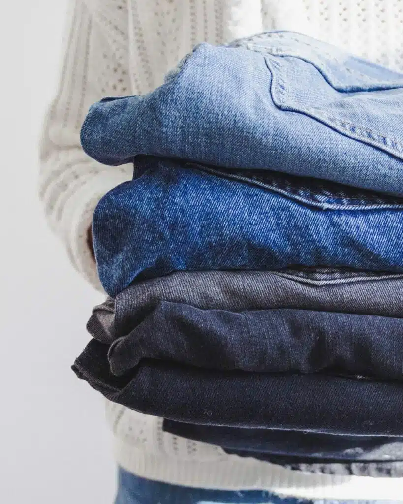 Neatly folded jeans in various shades and styles, presenting a classic and versatile clothing option for casual and stylish outfits.