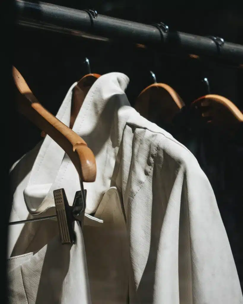 A pristine white shirt hanging on a hanger, showcasing a timeless and versatile wardrobe essential.