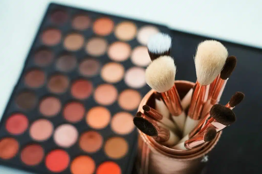 Image showcasing a variety of eyeshadows in different hues, paired with an assortment of professional makeup brushes.
