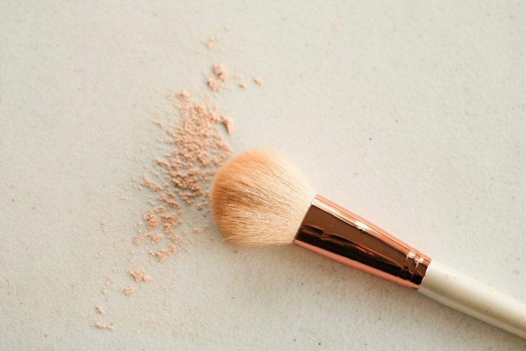 Close-up image of a professional makeup brush against a clean, neutral background, highlighting the fine, soft bristles designed for precise application of cosmetics.
