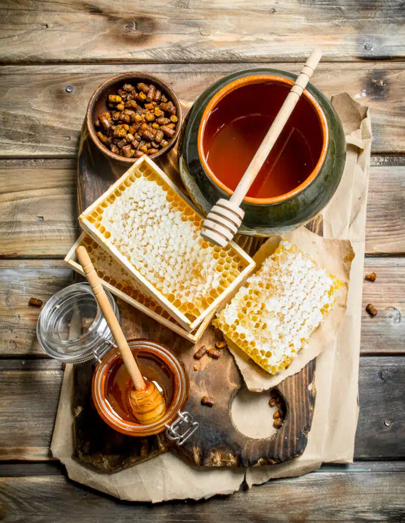 Assortment of different types of honey. On a wooden background.