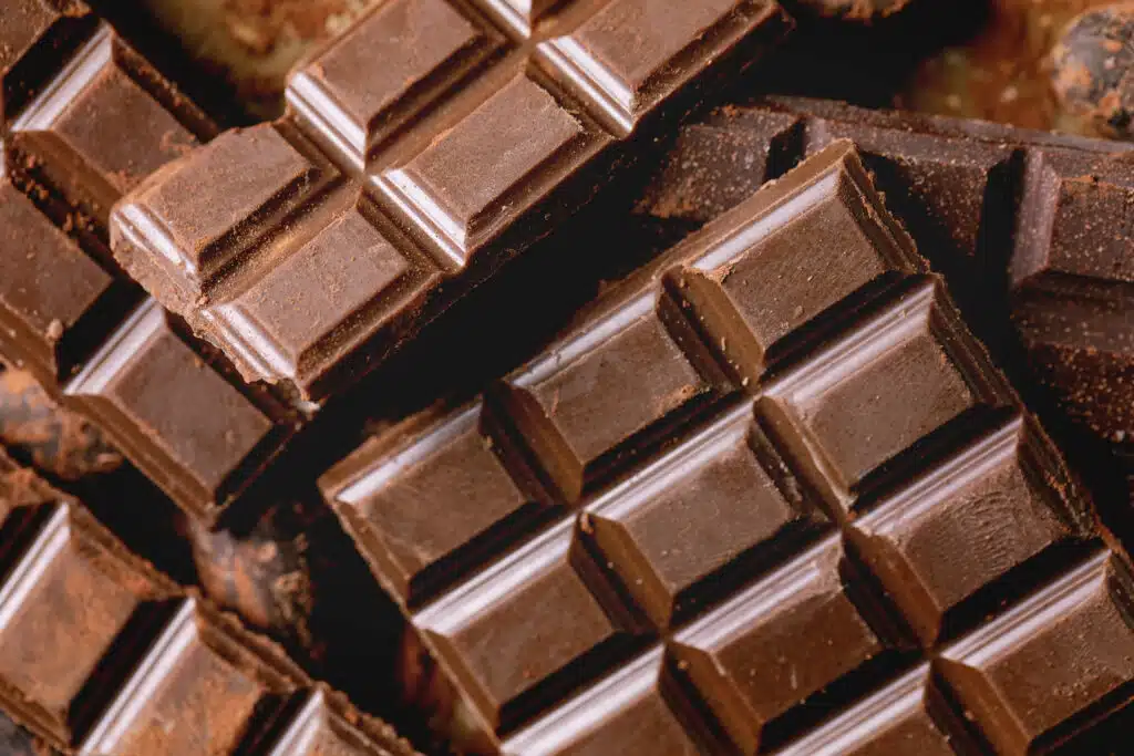 Dark and milk chocolate bar whole and chopped with cocoa beans and cocoa powder. Food background. Flat lay, close up