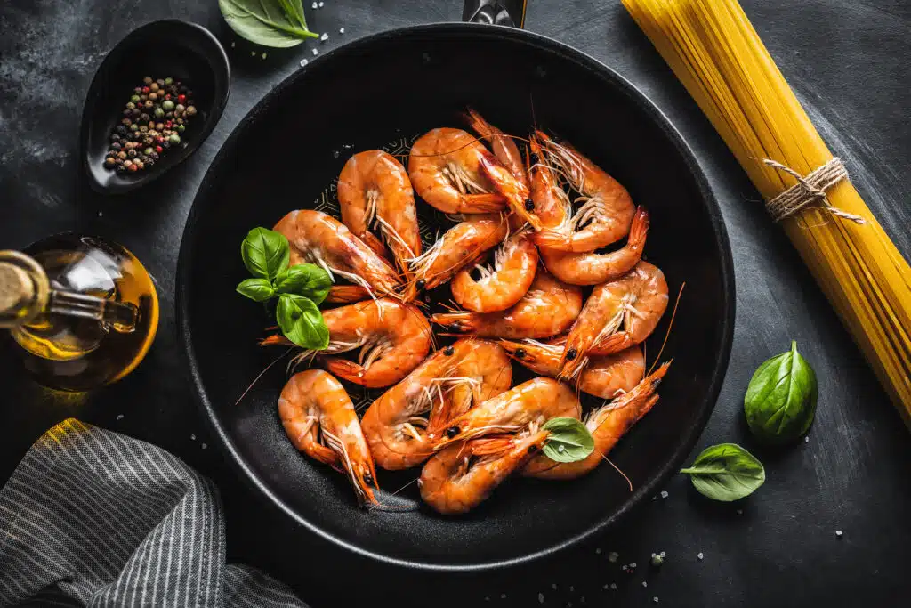 Fried shrimps with sauce on pan. Closeup.