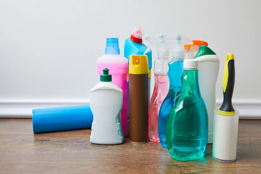 bottles with cleaners and spray bottles on floor