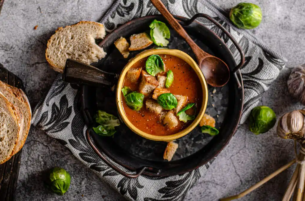 Delish soup with meat, crispy bread and grilled brussels sprout