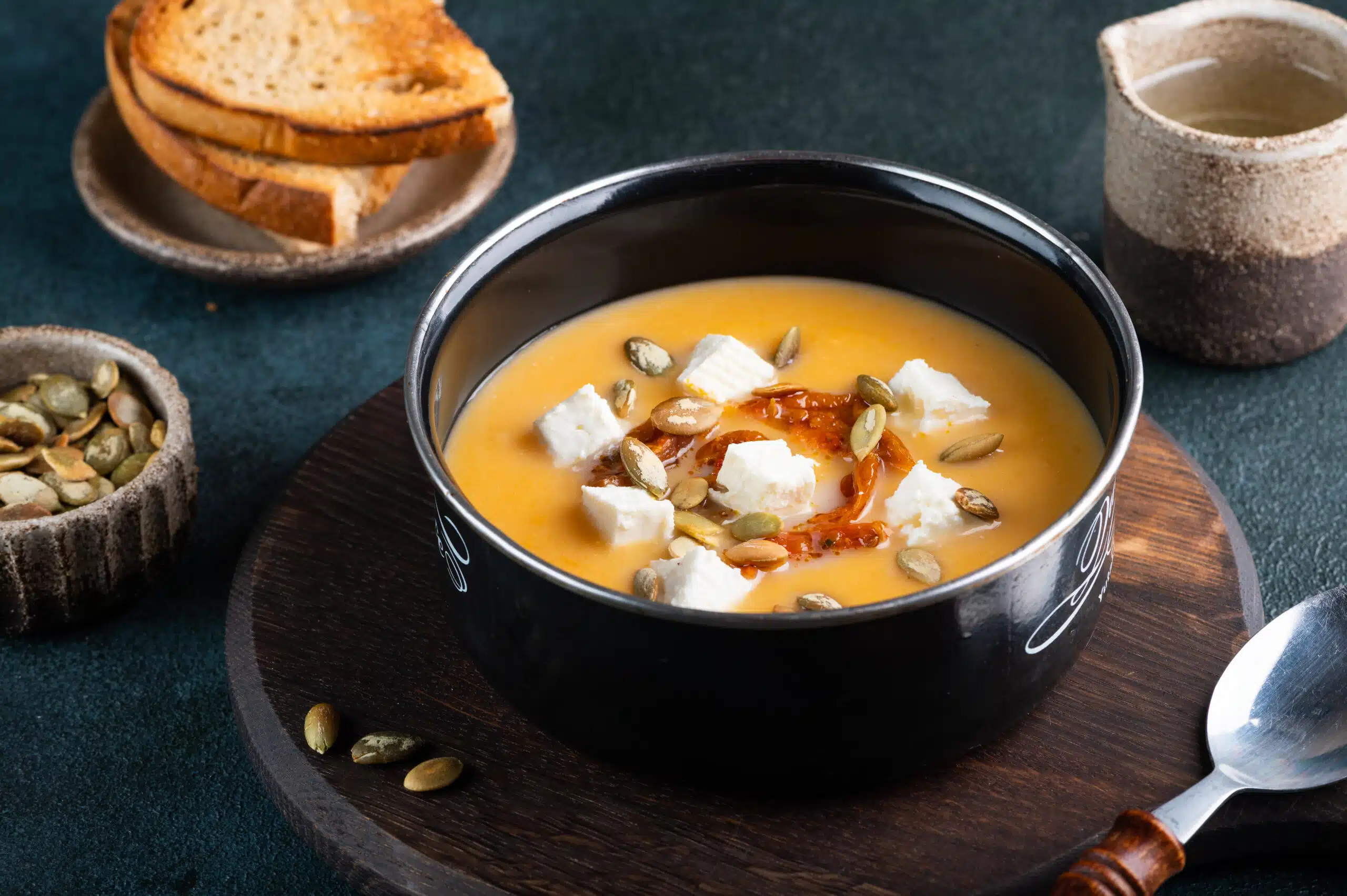 Pumpkin soup with feta and tomatoes. Soup with seeds. Carrot soup with cheese. Vegetarian soup