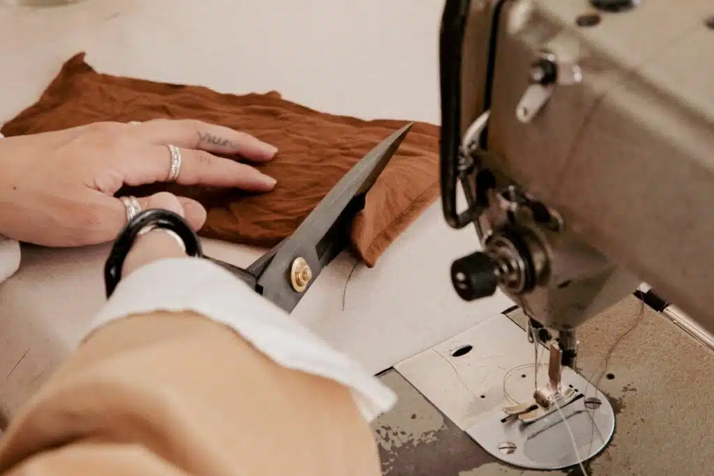 A skilled woman attentively working on a sewing machine, illustrating the precision and craftsmanship involved in European clothing manufacturing.