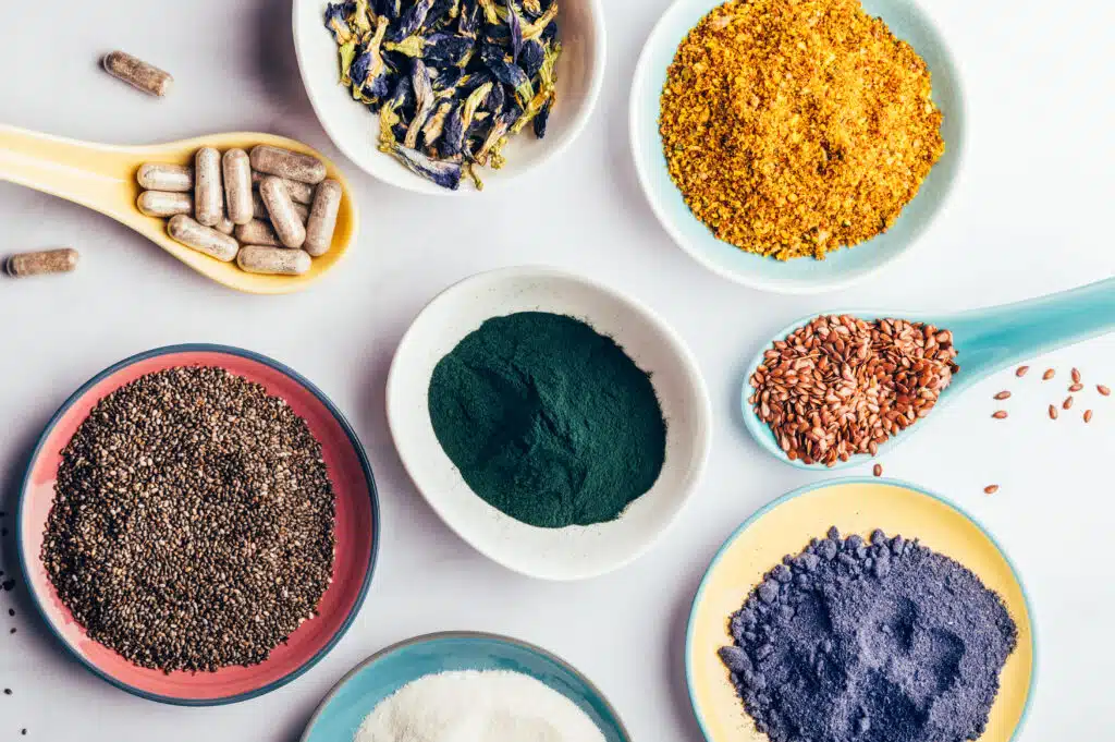Variety of healthy food supplements such as blue matcha, butterfly pea flowers, collagen powder, spirulina powder, vitamins for vegans and vegetarians, flax and chia seeds,