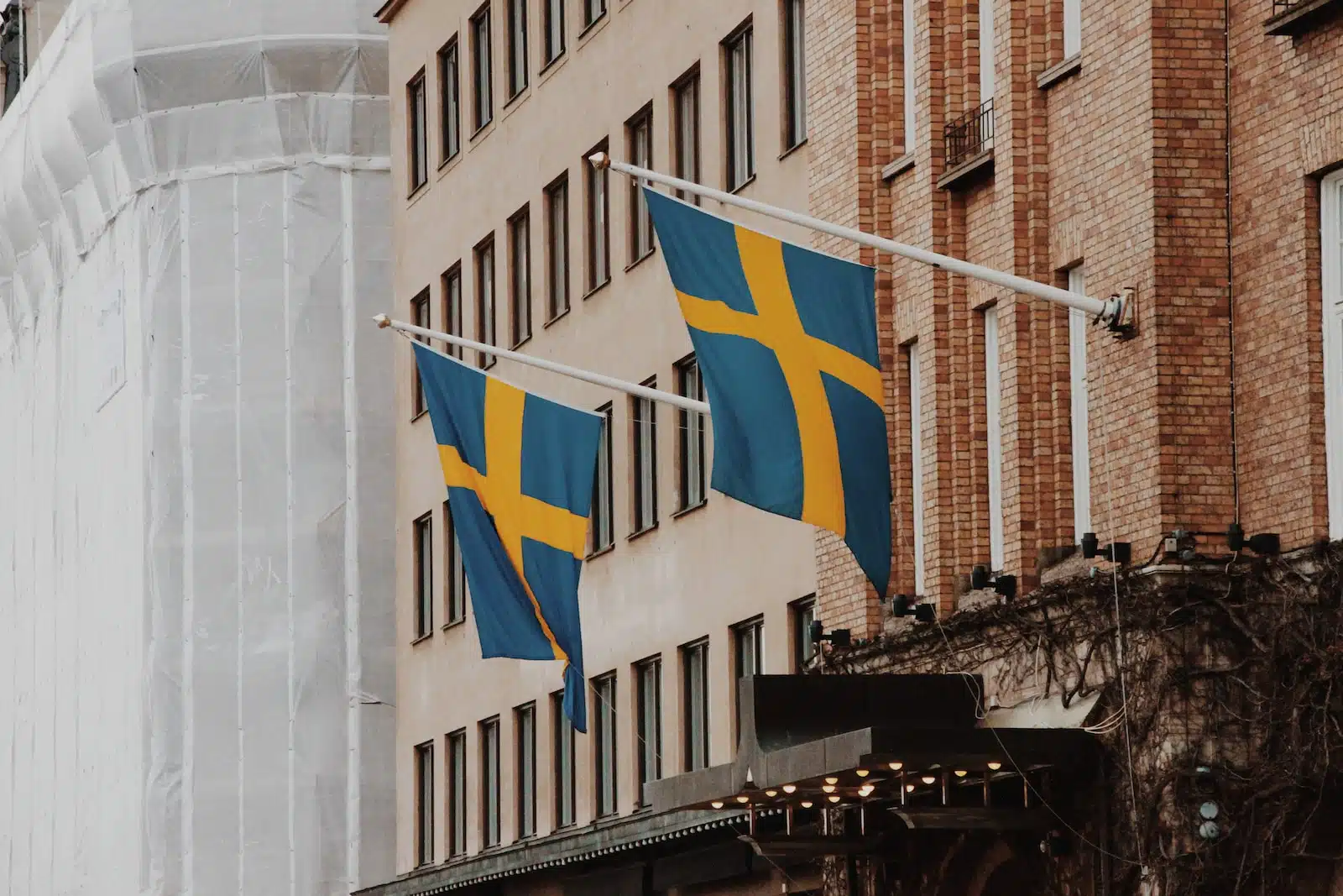a couple of flags hanging from the side of a building
