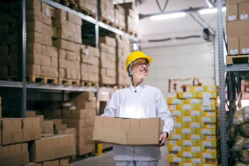 An inventory worker, clad in a safety vest, meticulously organizing and checking items in a well-stocked warehouse, ensuring accurate stock levels and efficient order fulfillment.