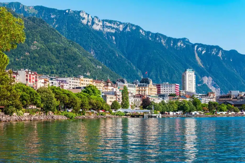 Scenic view of Geneva, showcasing its iconic landmarks, serene lake, and surrounding mountains.